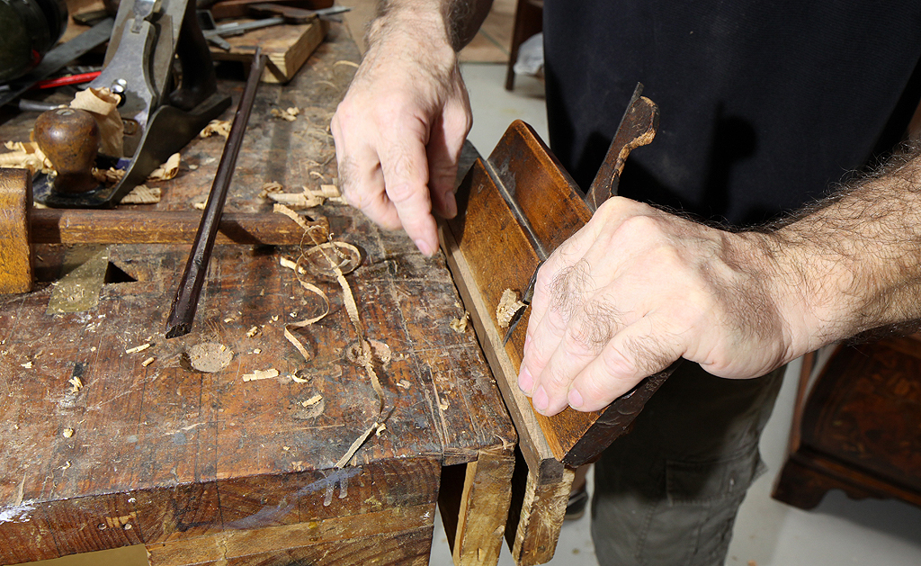 Calvert Regan, master craftsman at work with an antique molding plane.